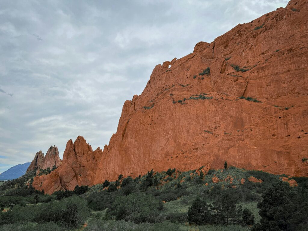 Majestic red rock cliffs under cloudy skies in a famous nature park.