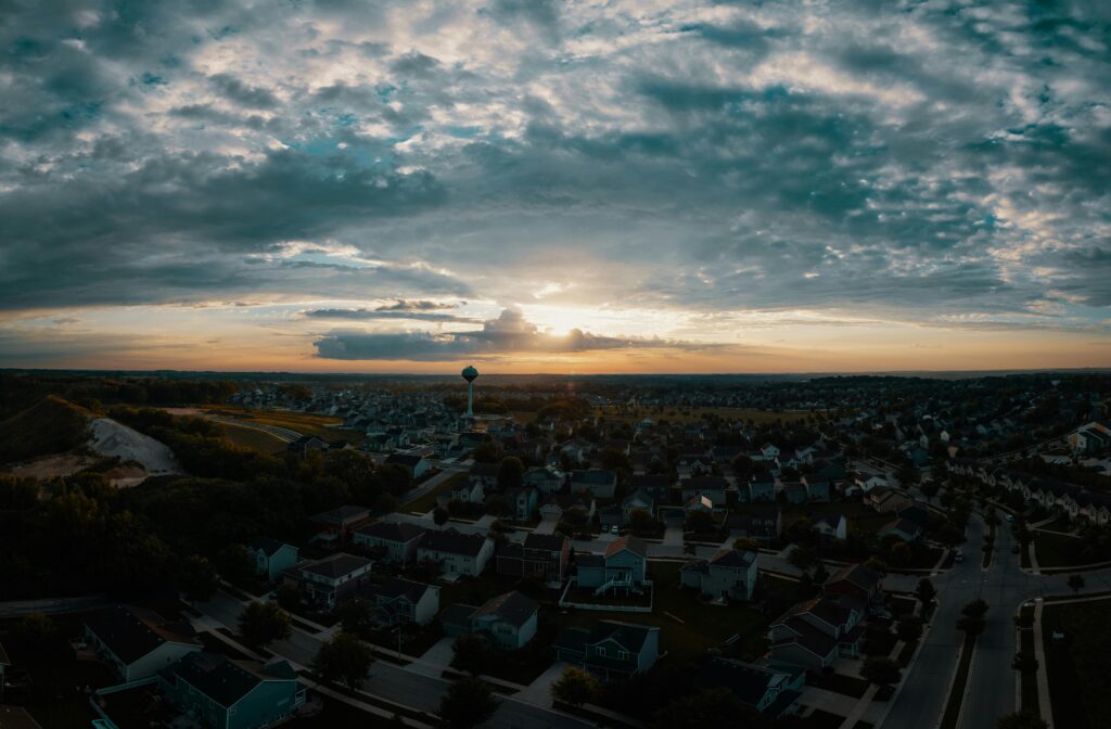 A stunning aerial panorama of Madison suburbs at sunset with a dramatic sky.
