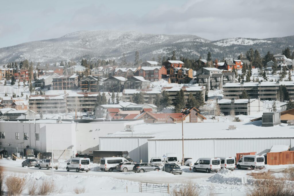 Panoramic winter view of a snow-covered town in Colorado with mountains in the background.
