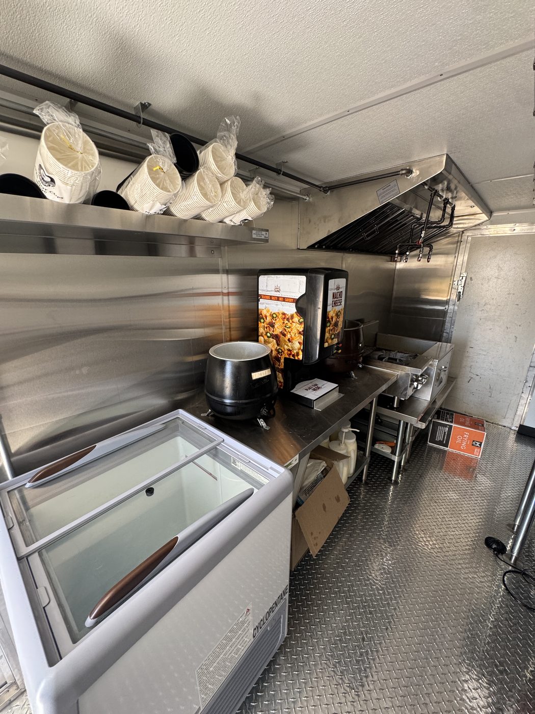 Cheese dispenser, soup pot and ice cream freezer along the stainless line inside the roasted corn truck