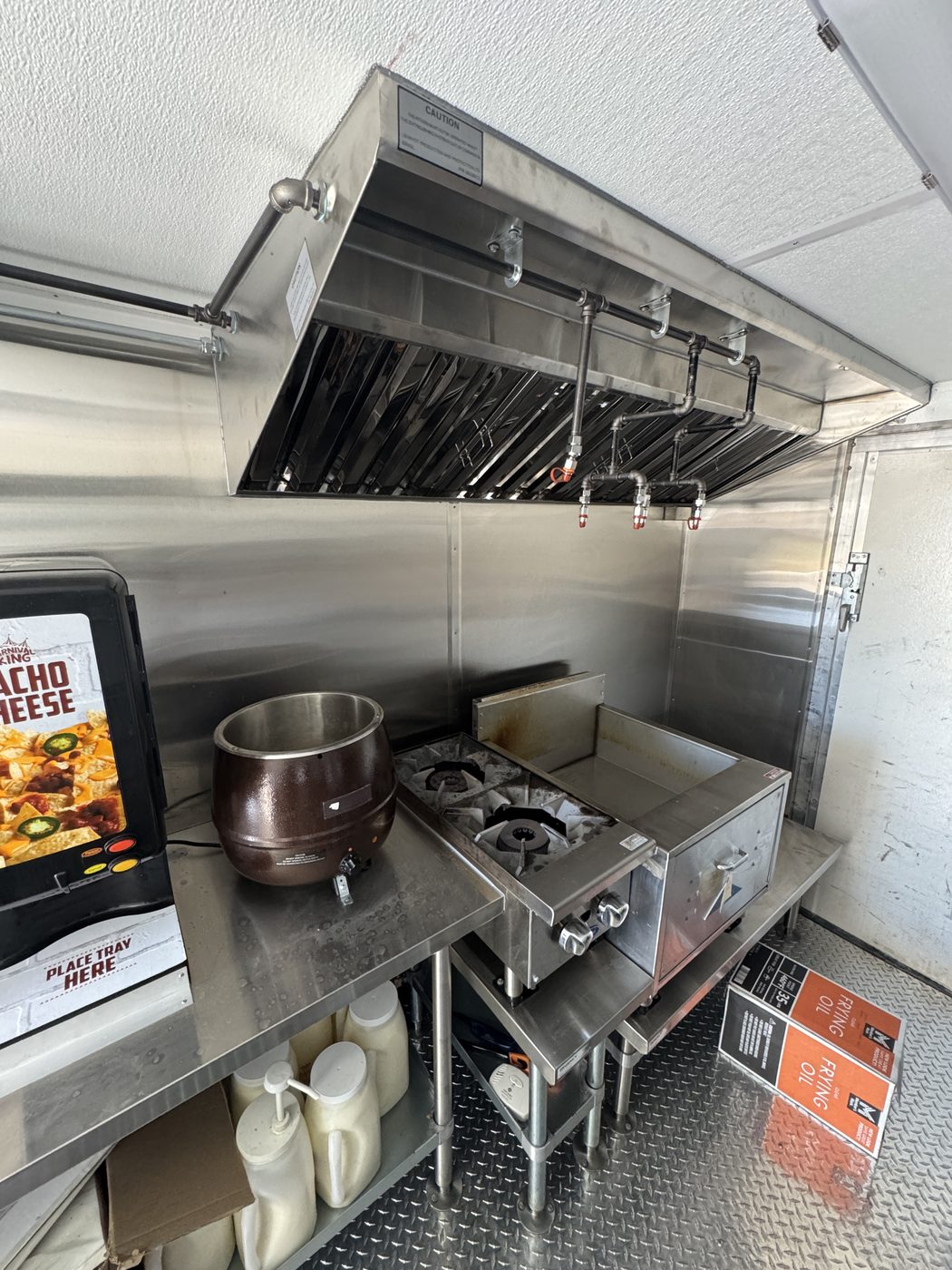 Type I hood with fire suppression nozzles above the two burner stove and soup kettle in the roasted corn food truck