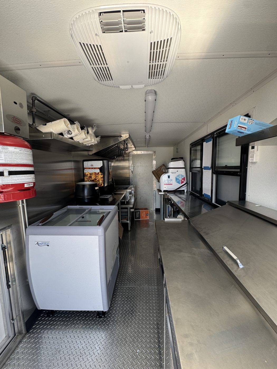 Interior of the 14ft roasted corn food truck looking toward the rear, showing the rooftop AC, ice cream freezer and stainless line
