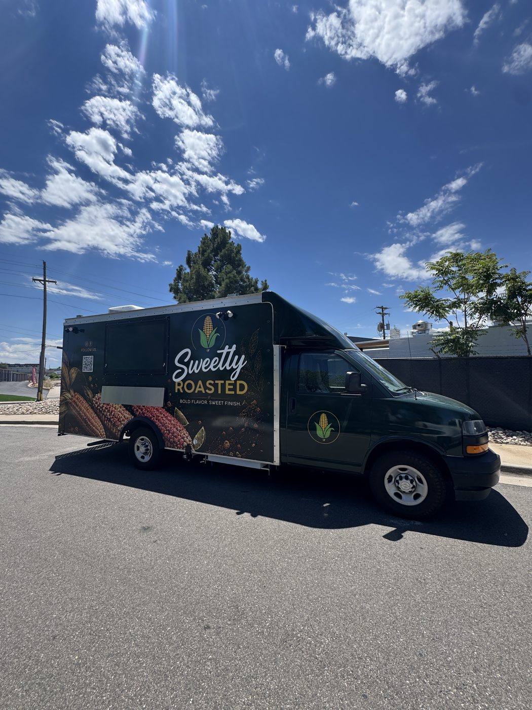 Driver side of the 14ft roasted corn food truck showing the Sweetly Roasted logo and corn artwork on a dark green wrap