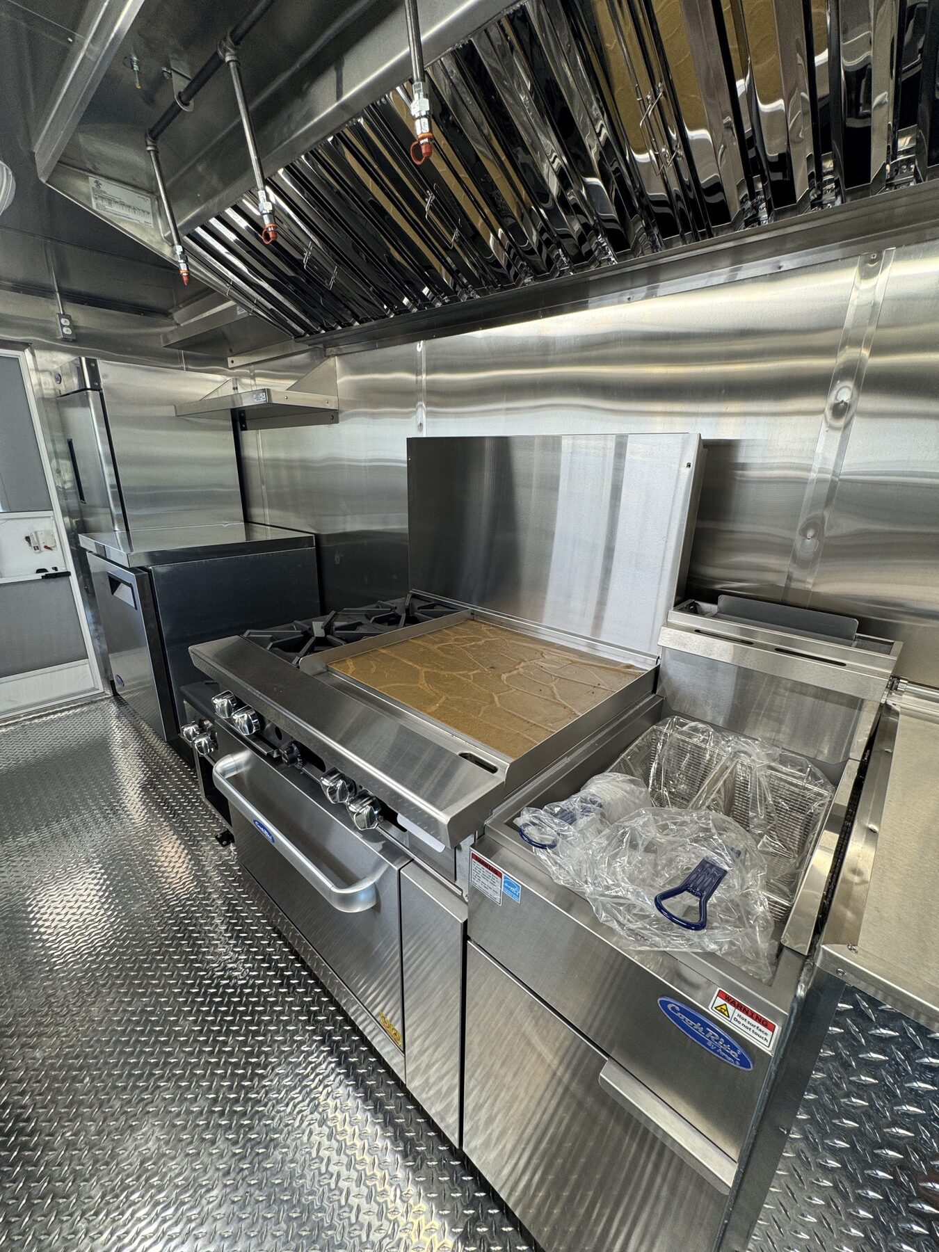 Atosa range with a twenty four inch griddle and a forty pound fryer under the six foot Type 1 hood