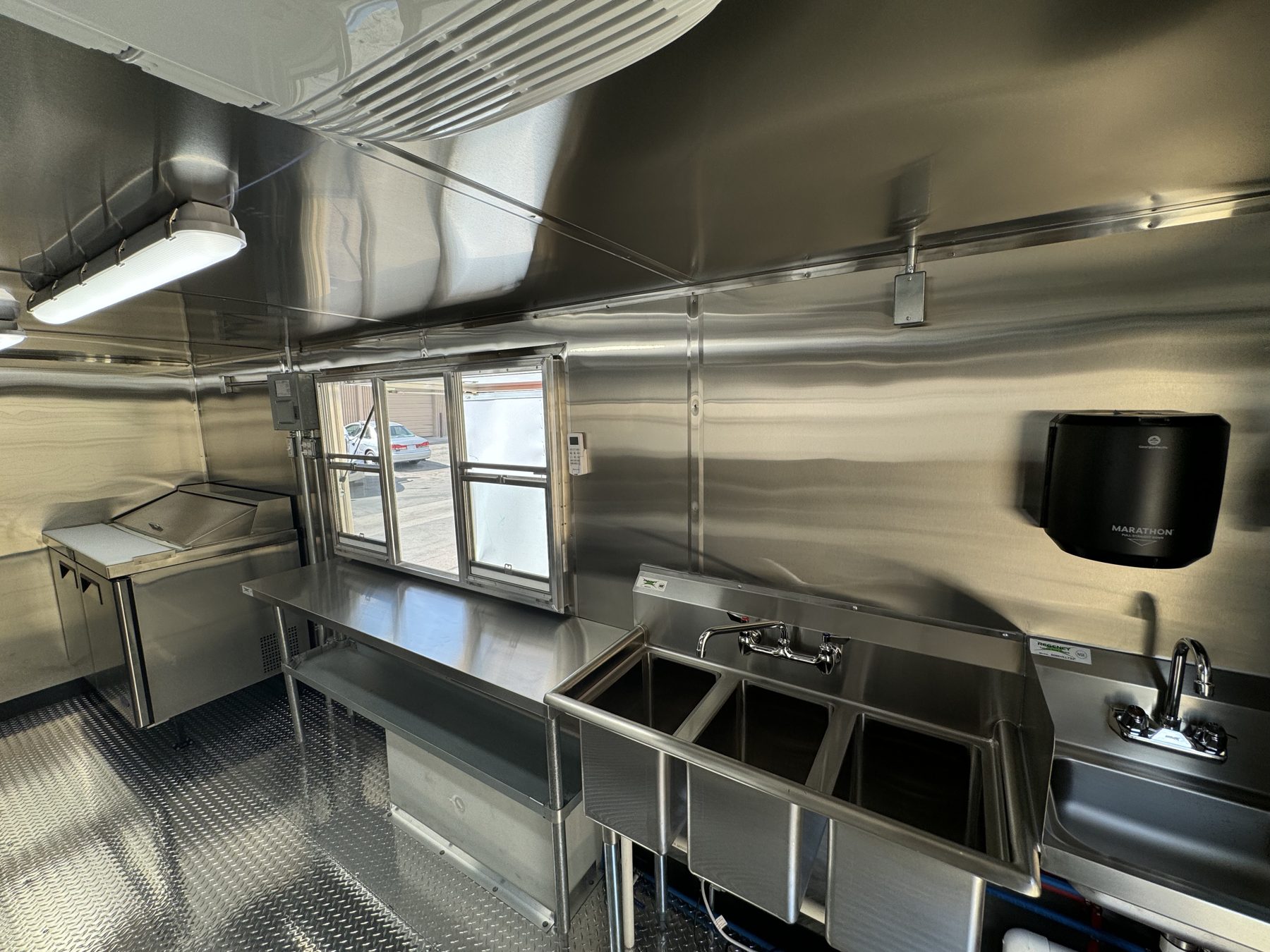 48 inch sandwich prep table, three compartment sink and hand sink under the window in the taco truck