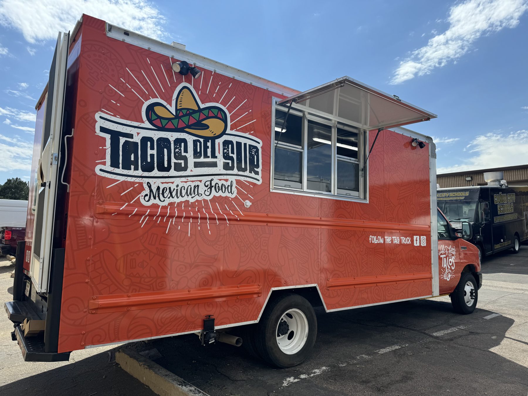 Service side of the Tacos del Sur truck with the window open and the Mexican Food wrap
