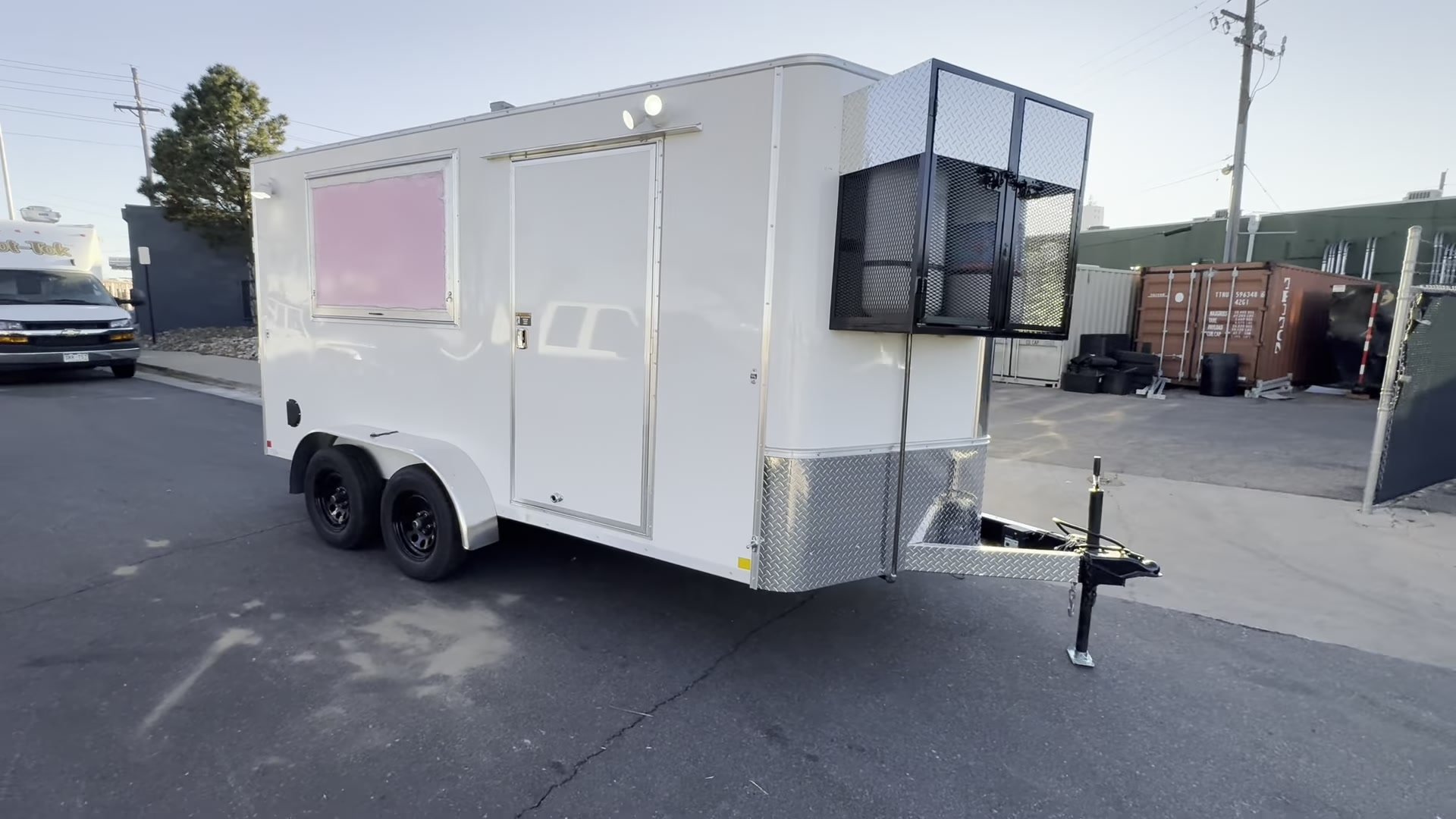 12ft white enclosed food trailer with double axles and a caged propane rack on the tongue, built for El Paso County, Colorado