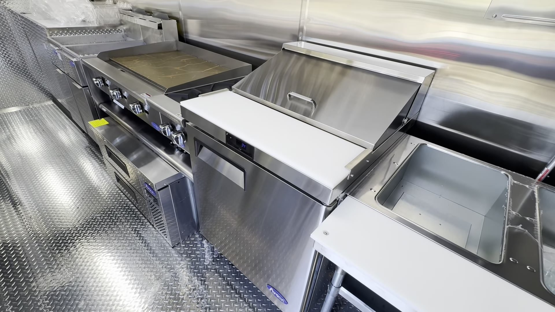 27 inch Atosa sandwich prep table beside the griddle and the two pan steam table