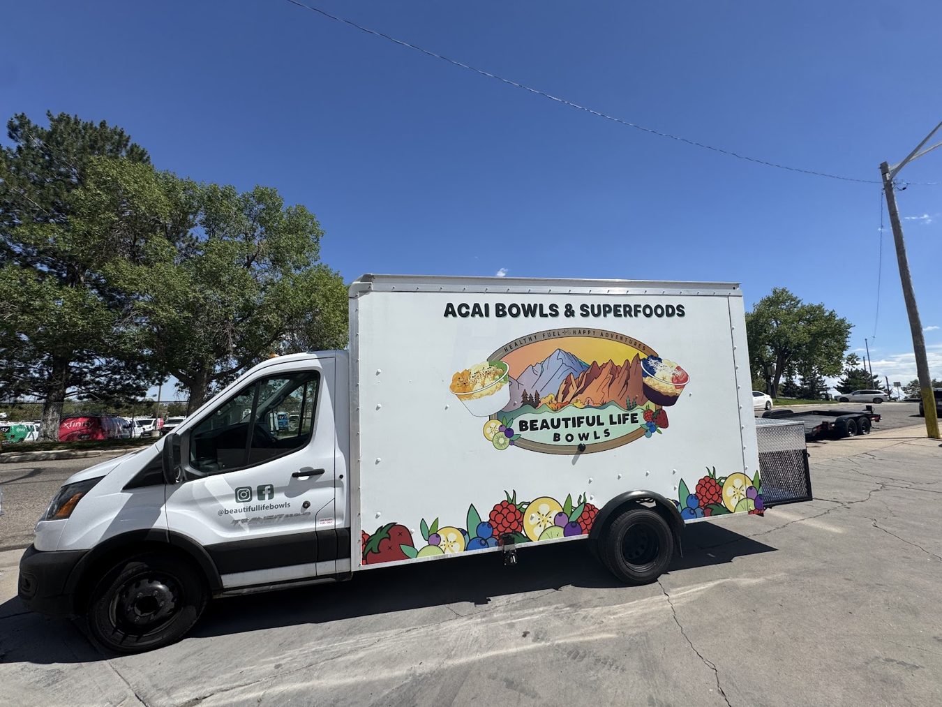 Beautiful Life Bowls açaí bowl food truck on a Ford Transit box truck in Fort Collins, Colorado, curb side with the service window