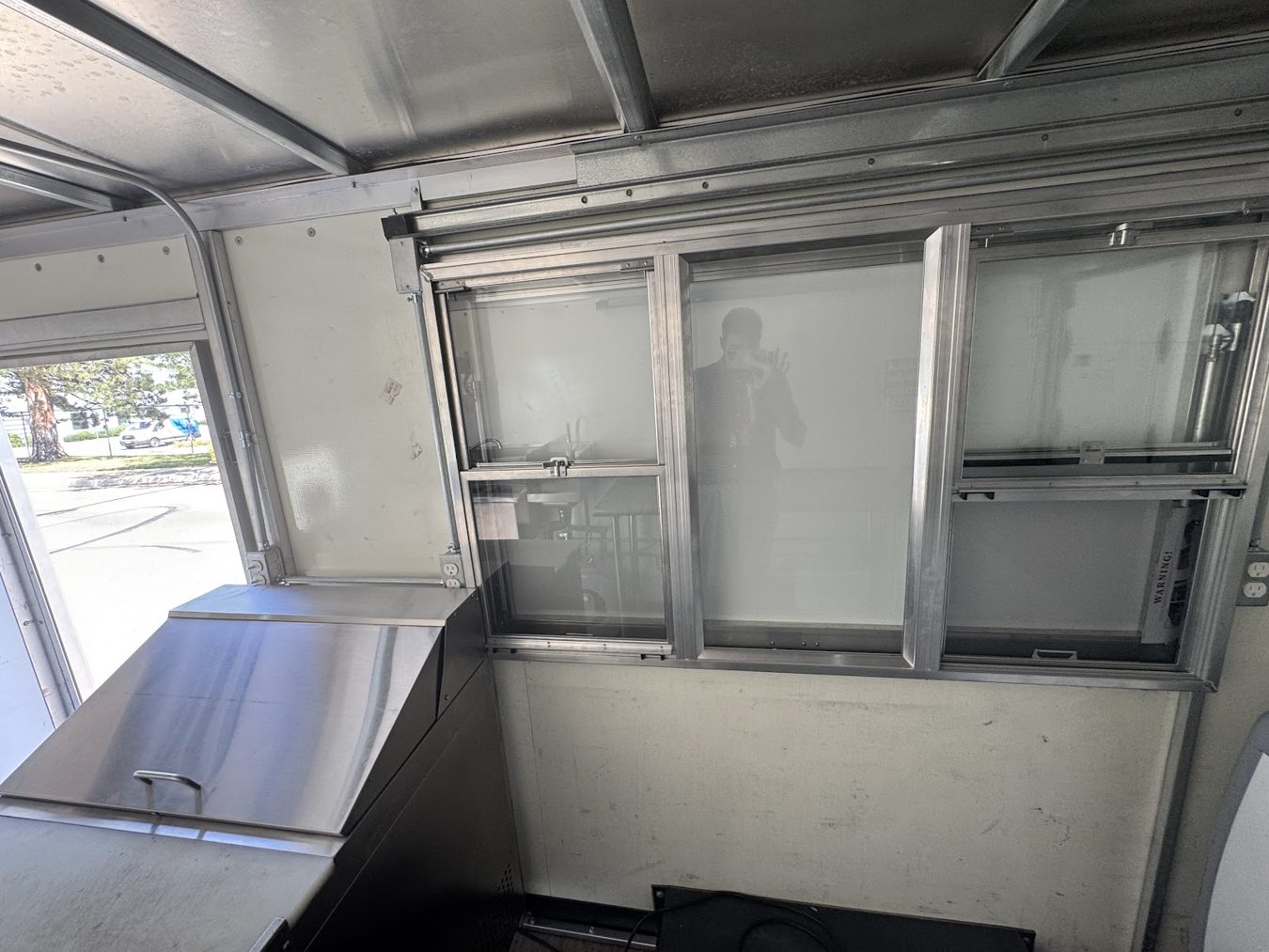 Service window seen from inside the açaí bowl food truck with the work table under it