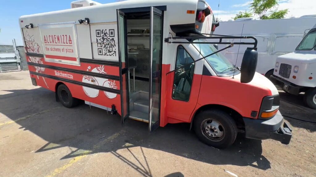 Alchemizza 14ft pizza food bus in a red and white wrap with the side door open, built for Boulder, Colorado