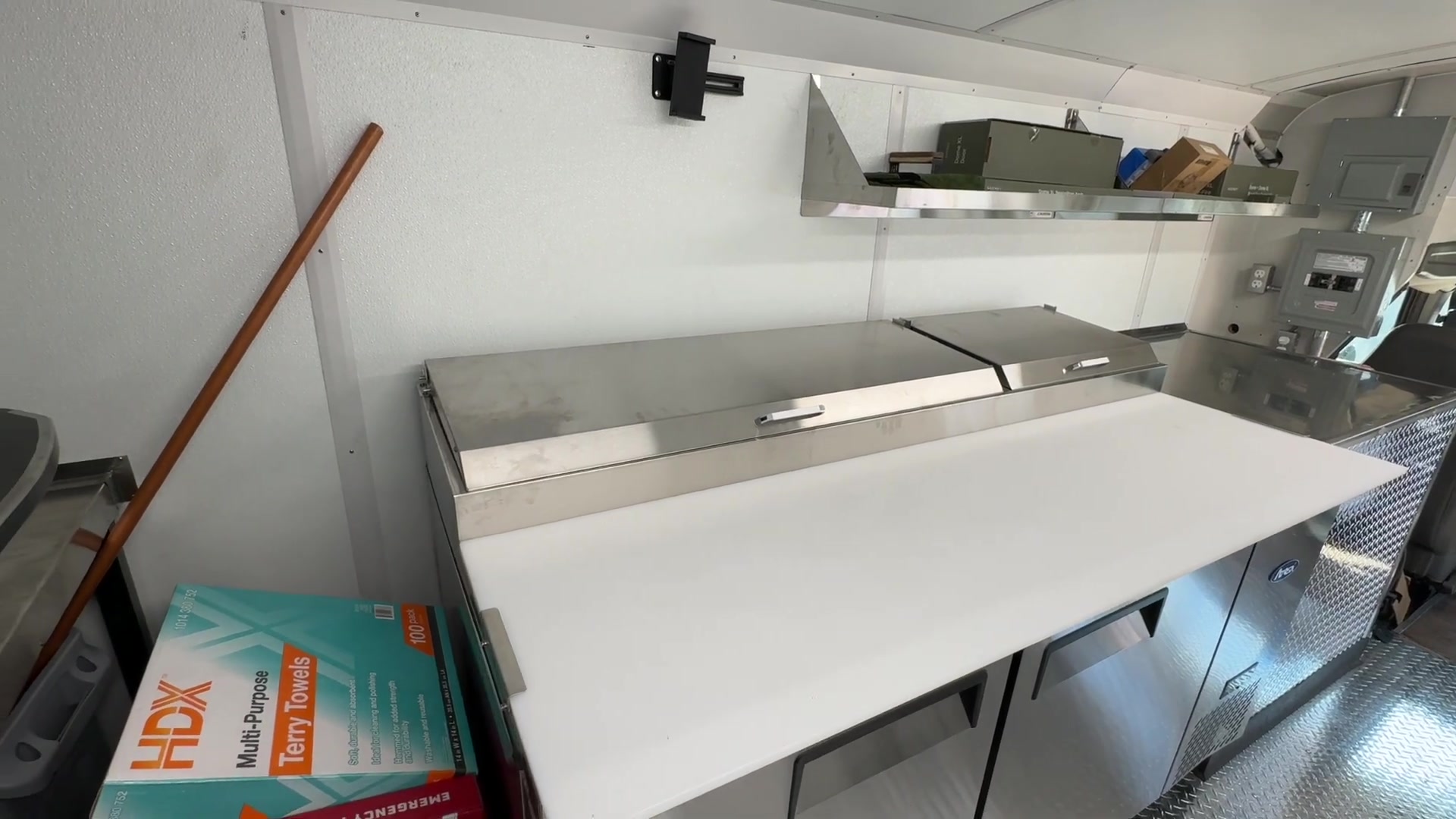 Atosa 67 inch refrigerated pizza prep table with a white cutting board in the food bus