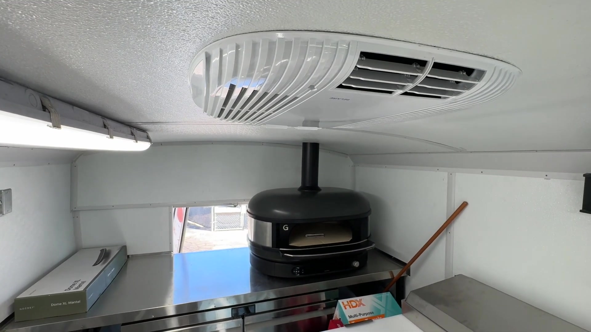 Ceiling air conditioner with heat above the Gozney oven and its flue in the food bus