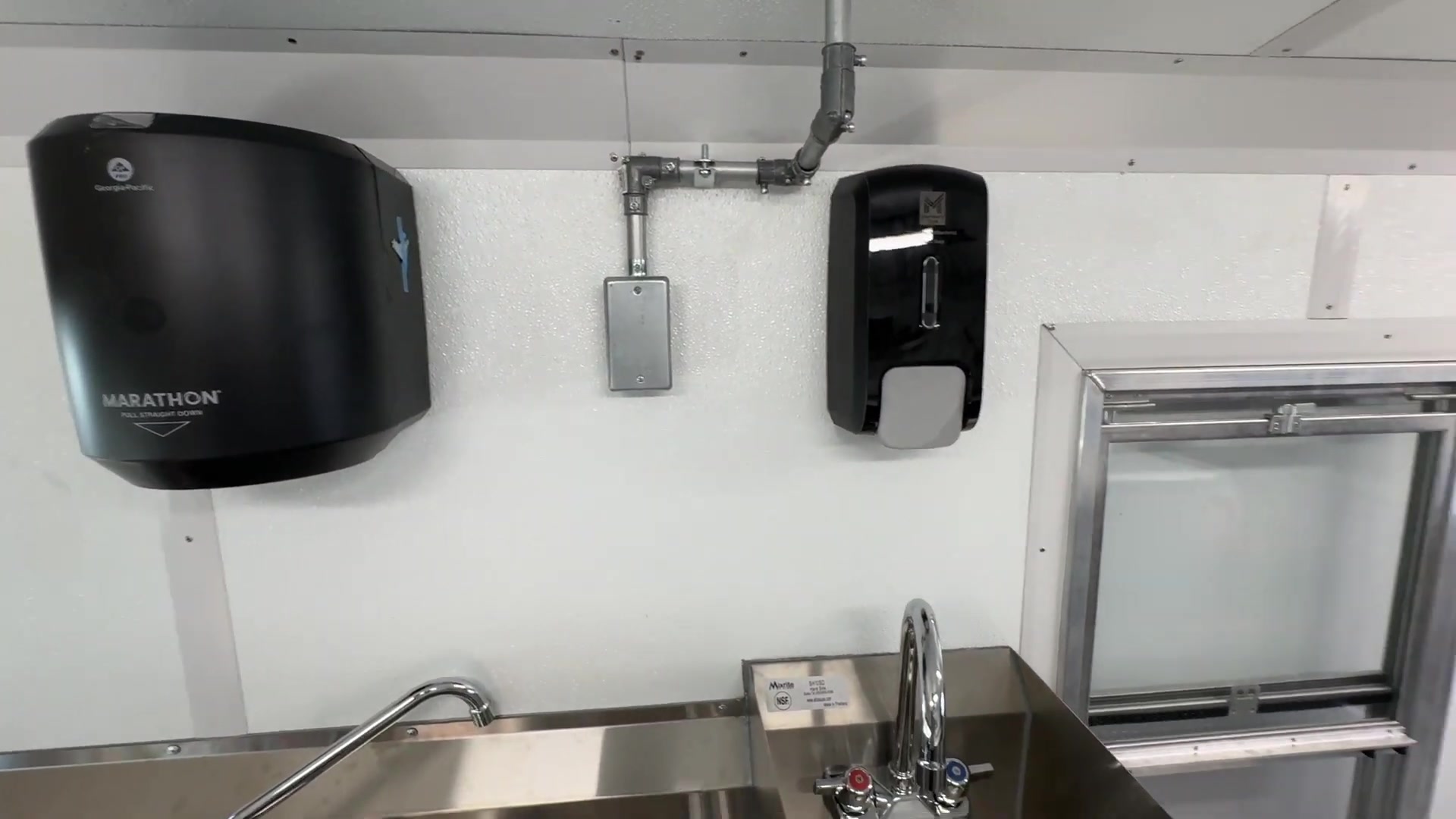 Hand wash sink with paper towel and soap dispensers in the food bus