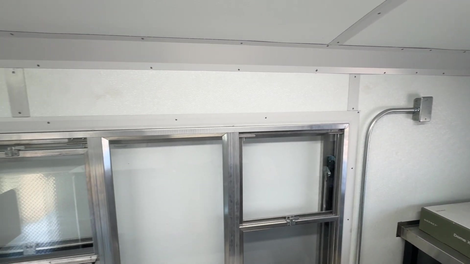 Five foot by three foot self closing three section service window from inside the pizza bus