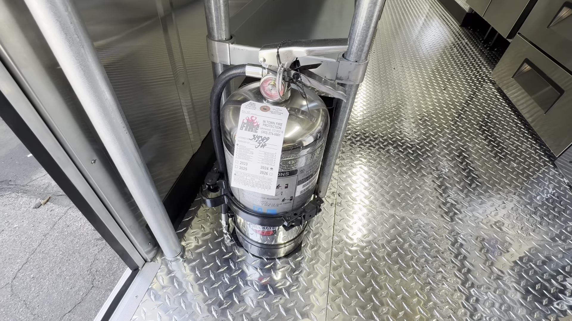 Class K fire extinguisher mounted by the door of the food trailer