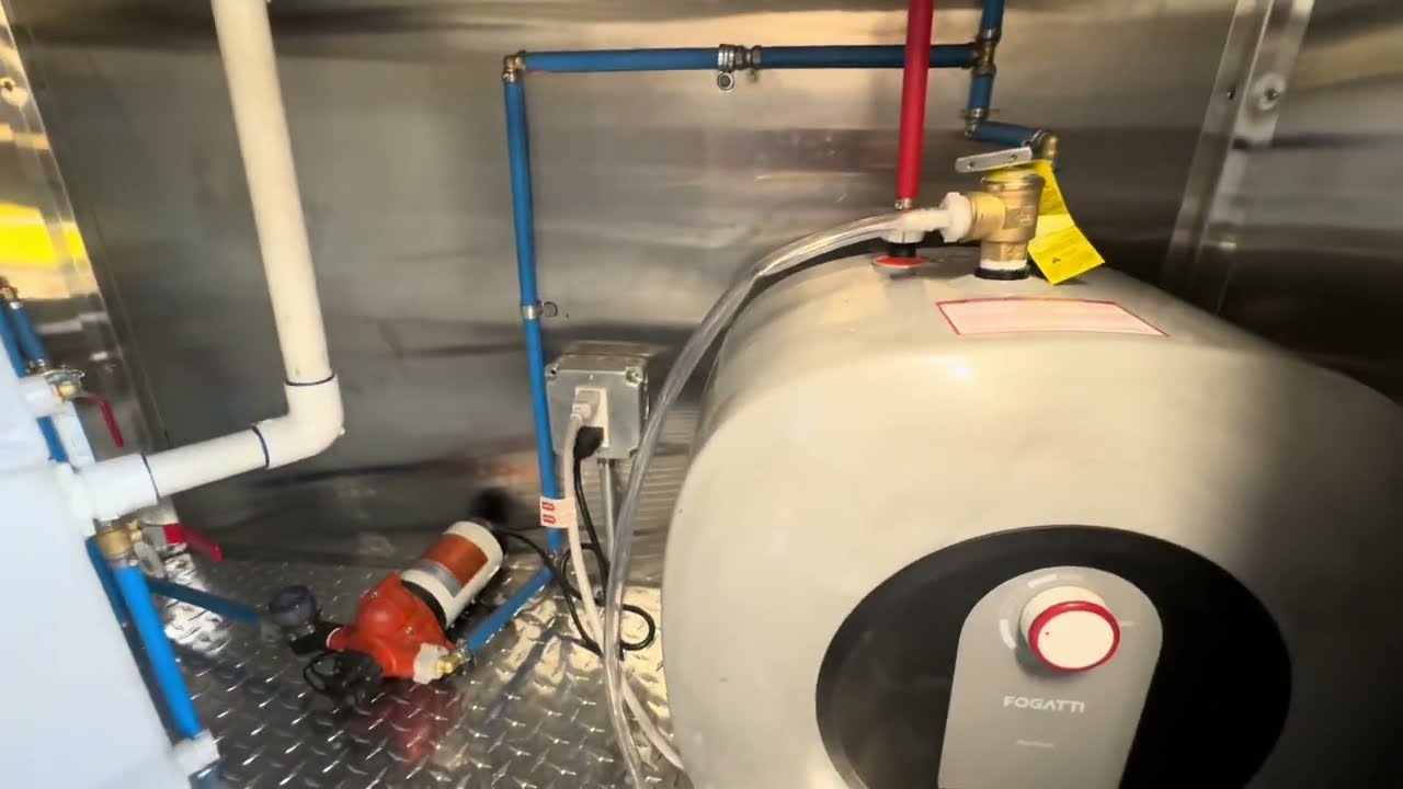 Water heater and plumbing under the counter of a 16 foot food trailer