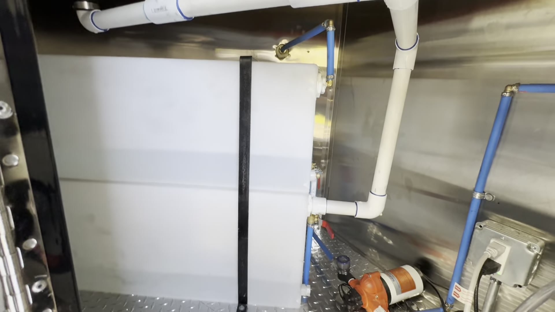 Water pump, plumbing and drain valves under the counter of the food trailer