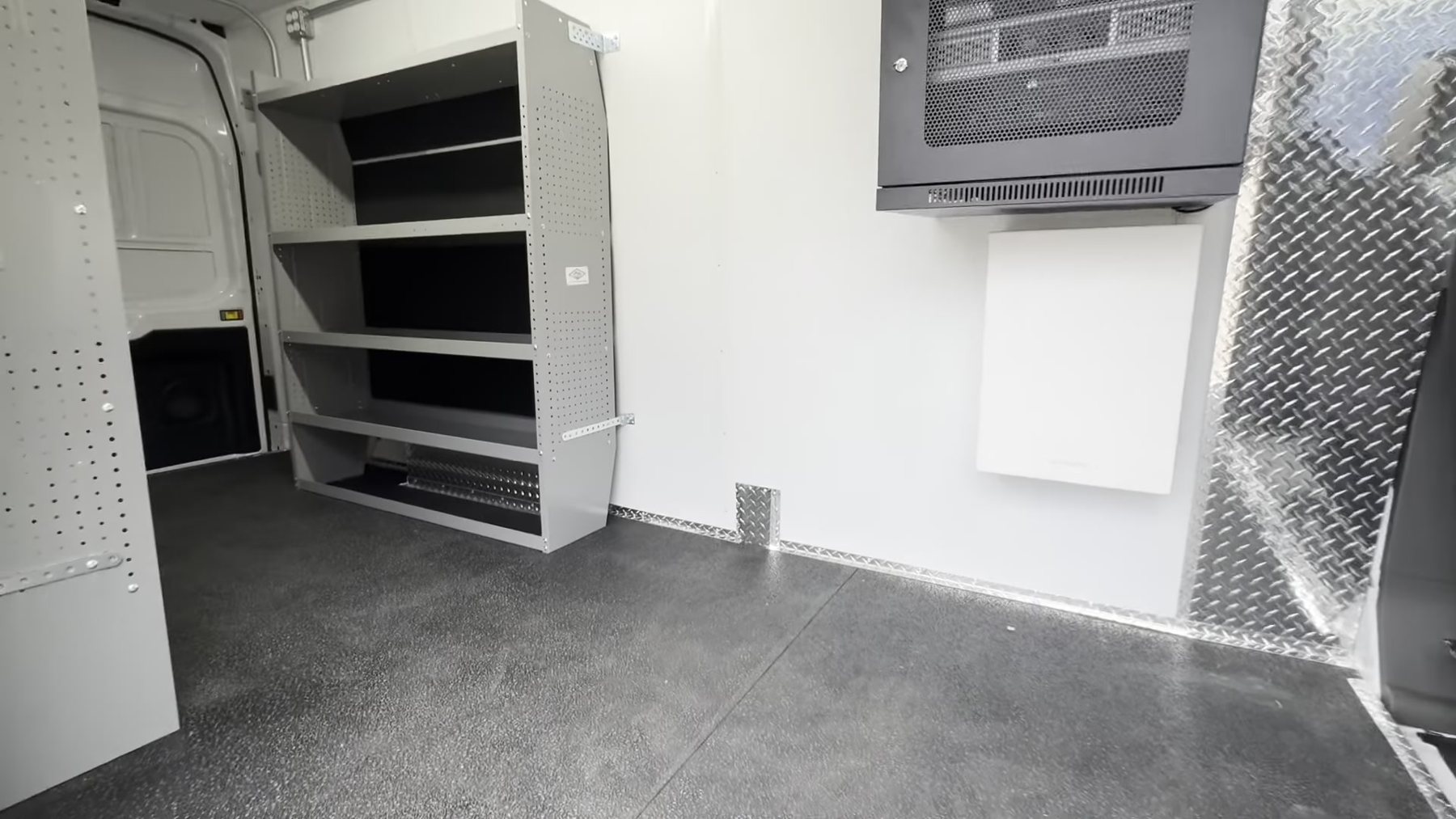 Interior of the outreach van with shelving, a wall mounted screen and a rubber floor